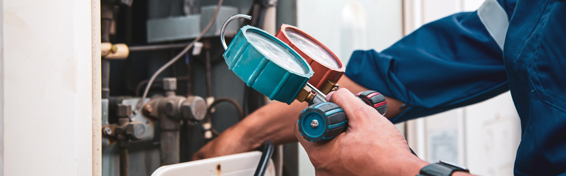 HVAC system service technician using measuring manifold gauge checking refrigerant and filling industrial air conditioner after duct cleaning maintenance outdoor compressor.